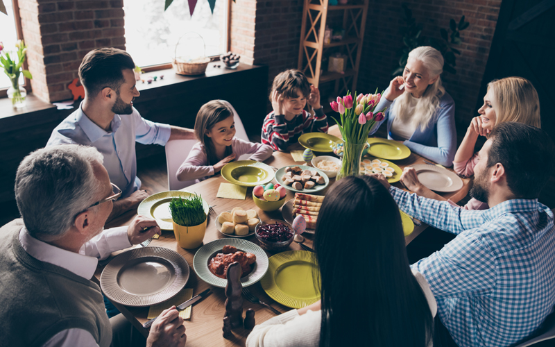 Eine glückliche Familie sitzt am Tisch.