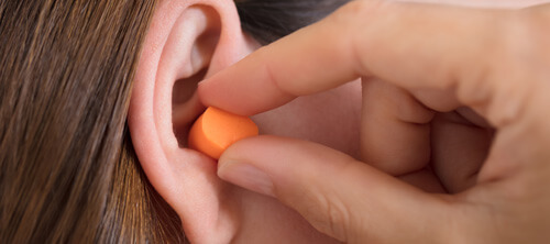 Frau mit Gehörschutz im Ohr